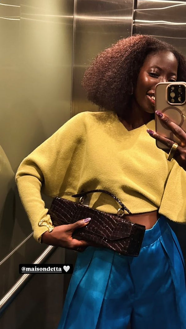 A customer wearing the Tita croco bag